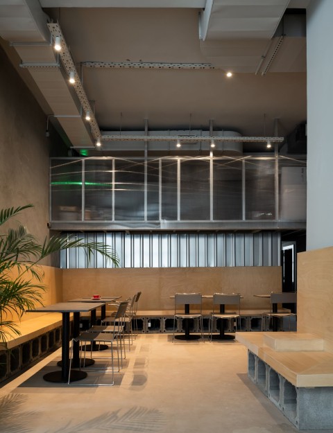 Cafe seating with plywood cubes and concrete finishes at Chernyi Cooperative Coffee Roasters