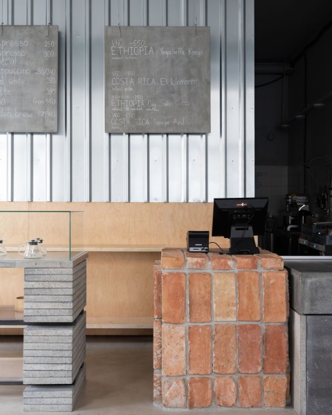 Historical brick counter and concrete menu boards at Chernyi Cooperative Coffee Roasters