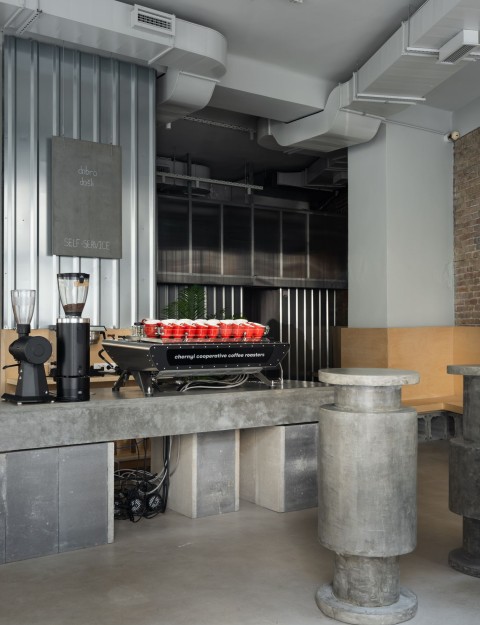 Self-service coffee bar with concrete tables at Chernyi Cooperative Coffee Roasters