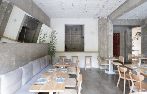 Embers Restaurant dining hall with light wood furniture and historical material layers