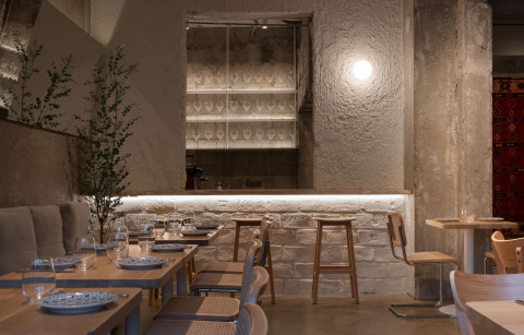Main dining room at Embers Restaurant with concrete walls and warm wooden furniture