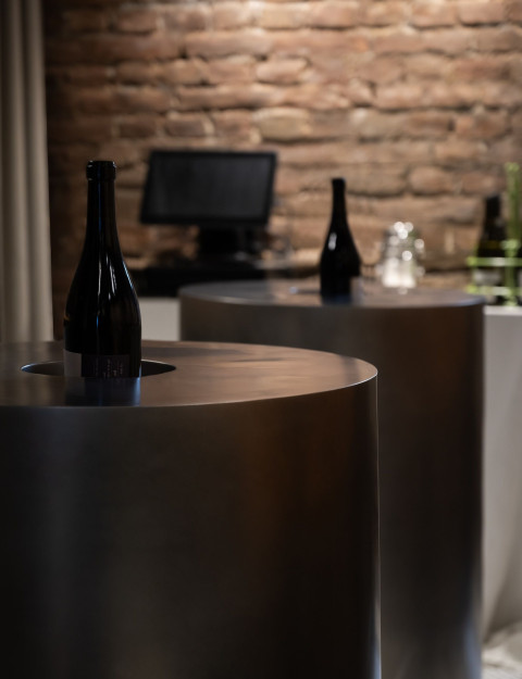 Vertical wine cellar detail at Fresca with stone wall texture and bar elements