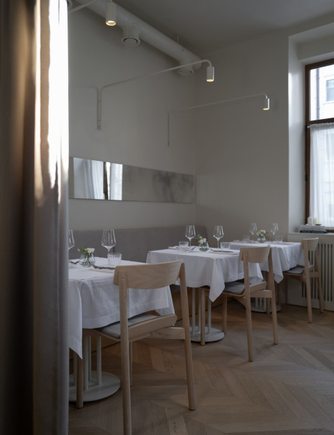 Vertical detail of vintage furniture and soft material palette inside Fresca Restaurant