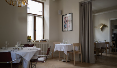 Large dining room view at Fresca Restaurant with creamy walls and discreet lighting