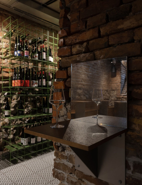 Vertical cellar view with raw masonry, wine storage and warm architectural lighting