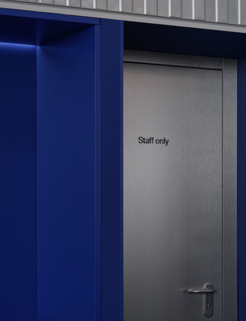 Vertical changing room detail at Gate-X Fitness Club with dark surfaces and precise lighting