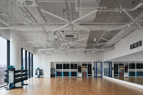 Wide interior view of Gate-X Fitness Club with integrated light strips and dark textures