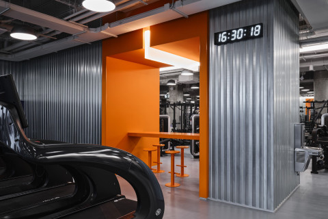 Orange bar zone at Gate-X Fitness Club contrasting with the dark futuristic interior