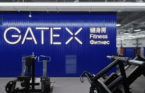 Wide corridor view at Gate-X Fitness Club with translucent glass and glowing architectural lines