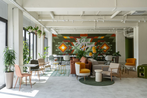 Wide workspace area at Haos Community Space with desks, glass partitions and terracotta accents