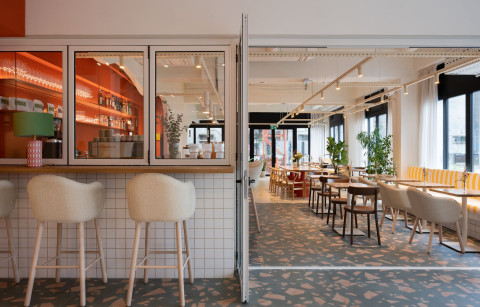 Wide green corridor at Haos Community Space connecting private offices and phone booths