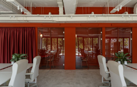 Wide open coworking area at Haos Community Space with workstations, shelves and lounge seating