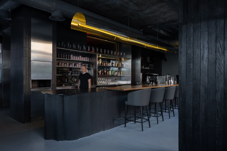 Hookah Restaurant dining hall with dark wood, orange accents and smoke-like lighting