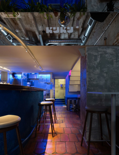 Bar counter detail with blue plaster and vintage color accents in KuKu Bar