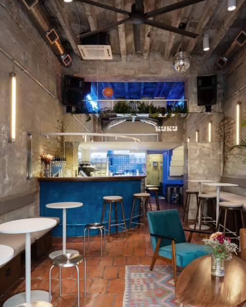 KuKu Bar lounge seating with vintage rug and low furniture by the window