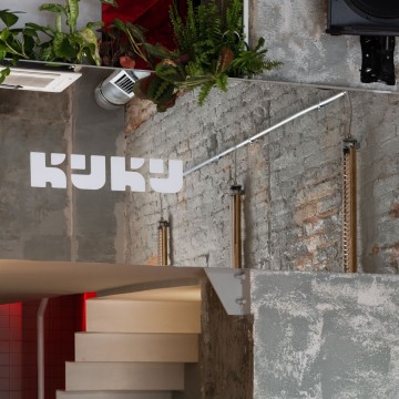 KuKu Bar vertical interior view with red lamps, blue plaster and glass block details