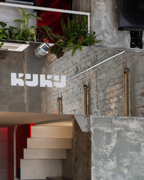 KuKu Bar vertical interior view with red lamps, blue plaster and glass block details