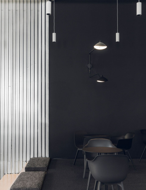 Mighty Buildings office material detail with corrugated metal wall, dark finish and suspended lights