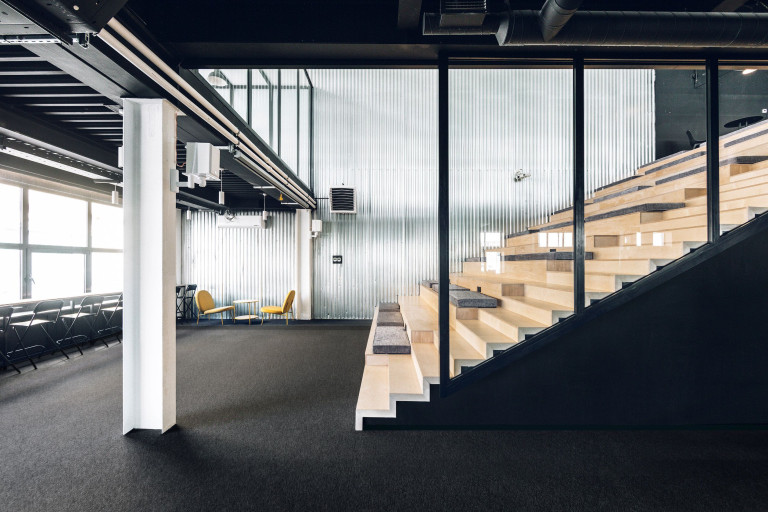 Mighty Buildings office amphitheater stair with industrial metal walls and open workspace