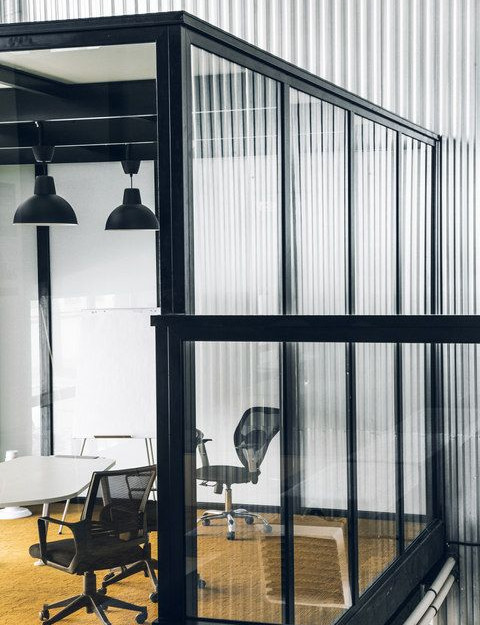Glass meeting room detail in the Mighty Buildings office with corrugated metal wall