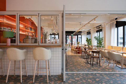 Main seating hall of Peers restaurant with soft curves and communal tables