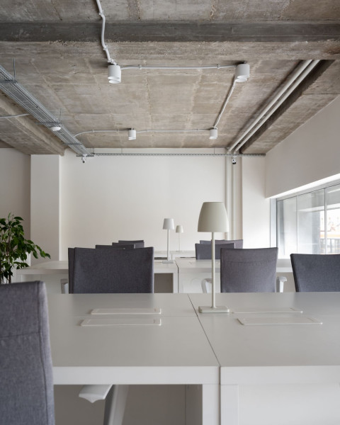 Glass partition detail connecting the meeting room and open workspace in PFU Coworking