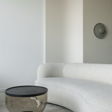 Curved sofa and smoked glass coffee table in a private office lounge