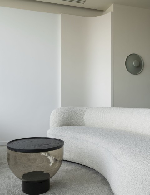 Curved sofa and smoked glass coffee table in a private office lounge