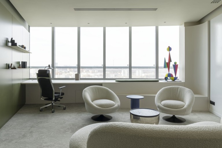 Private office interior with window desk, lounge chairs and city view