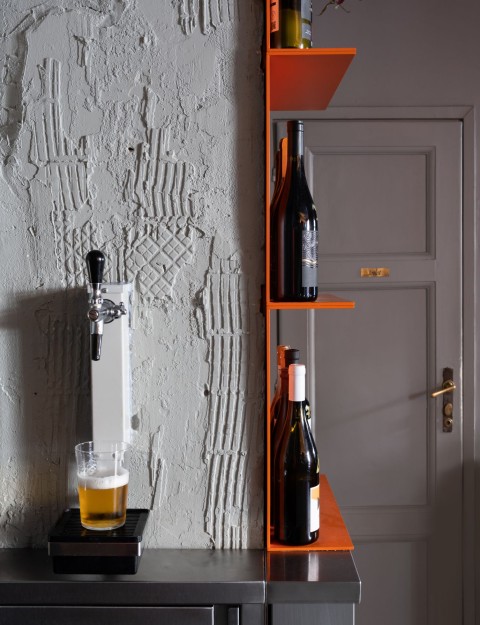 Orange light installation and raw wall detail inside Proces Wine bar