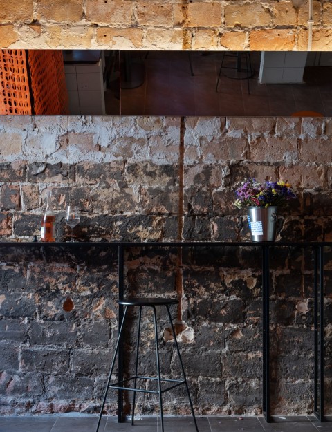 Building block bench and raw gray surfaces inside Proces Wine bar