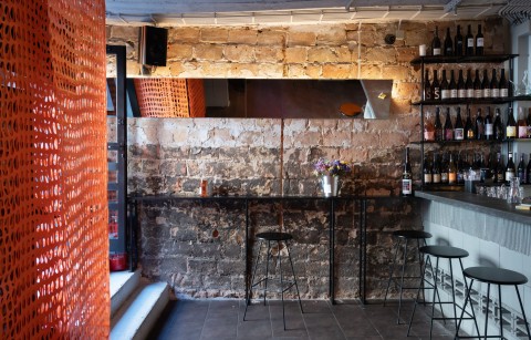 Proces Wine bar seating area reflected in a wall mirror