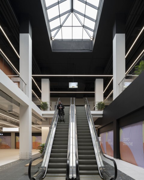 Siesta Shopping Center corridor with framed shopfront portals and black signage planes