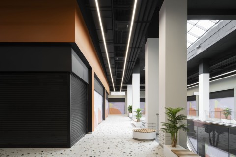 Upper gallery of Siesta Shopping Center with white retail portals and terrazzo floor