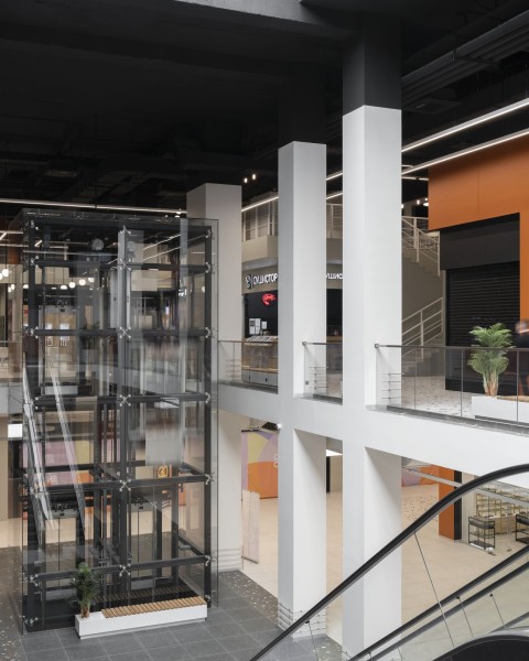 Vertical view of Siesta Shopping Center escalator void with terracotta and warm white surfaces