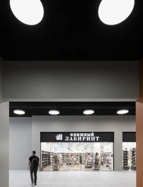 Vertical black signage plane and warm white interior detail in Siesta Shopping Center