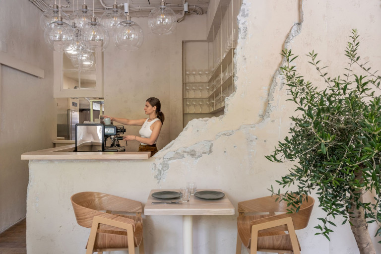 Stories restaurant dining room in Belgrade with beige surfaces, wooden furniture and warm lighting