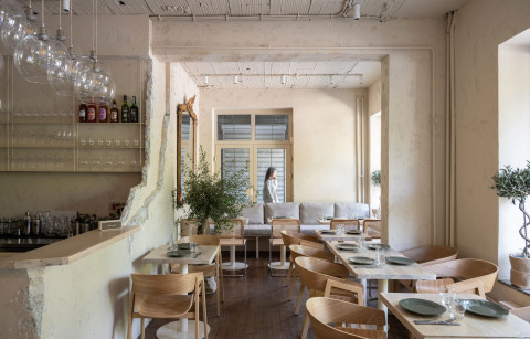 Stories restaurant window-side dining area with beige walls and wooden furniture