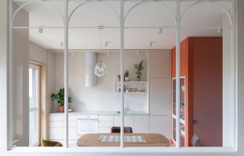 Terra Apartment kitchen viewed through a large arched glass partition