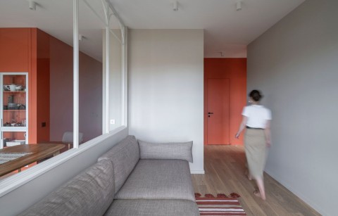 Terra Apartment living room with grey sofa, arched glass partition and terracotta hallway