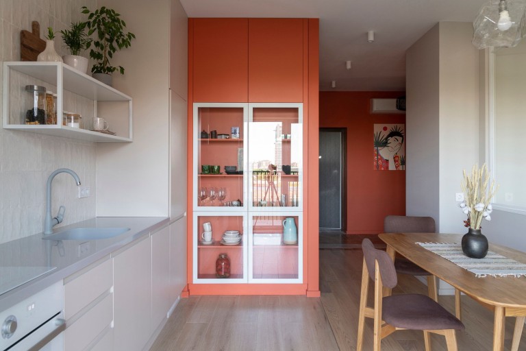 Terra Apartment kitchen and dining area with terracotta cabinetry and glass display storage