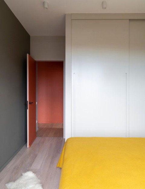 Terra Apartment bedroom with yellow bedspread, white wardrobe and terracotta doorway