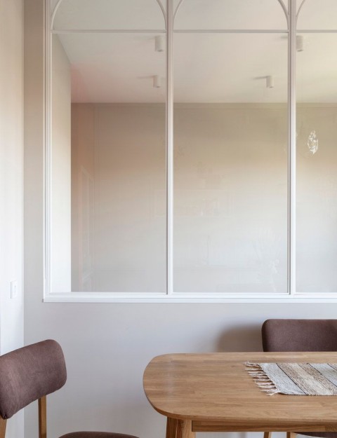 Terra Apartment dining detail with wooden table and translucent arched glass partition