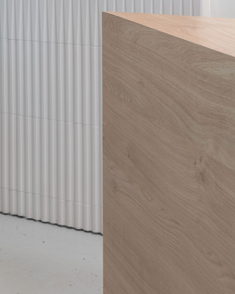 Bar counter detail with curved blue form and sandy textured surfaces in The Waterfront Cafe