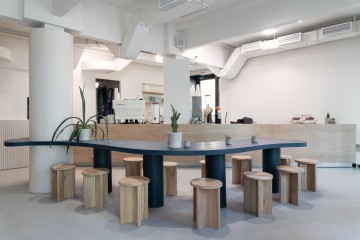The Waterfront Cafe interior with ocean blue wall, sand-toned seating and curved central dining table