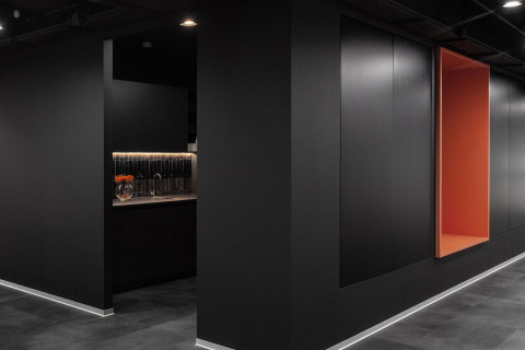 UNICA Office black corridor with orange niche and dark kitchenette