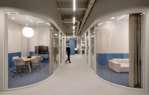 Wide open office area at Yandex Office 02 with desks, natural light and restored brick walls