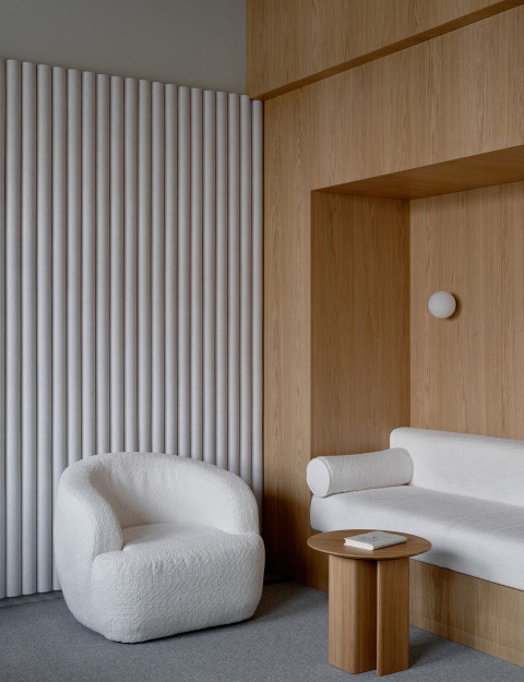 Vertical lounge detail at Yandex Office 02 with seating, plants and warm wood textures