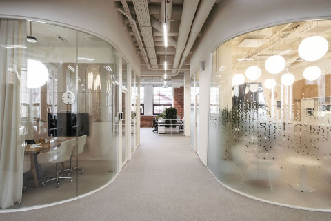 Desk area with ergonomic chairs and natural textures in Yandex Office 01