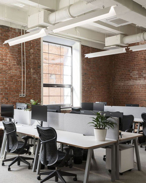Vertical view of Yandex Office 01 workspace with desks and restored brick walls